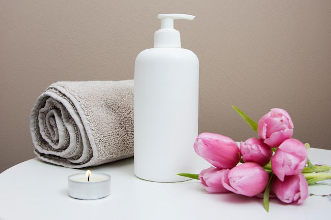Neatly arranged spa, salon towels with a bottle of lotion, symbolizing relaxation and self-care.