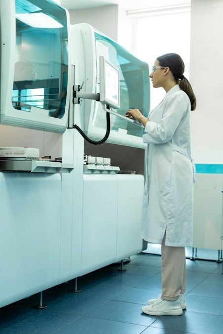 A laboratory technician carefully inspecting scientific equipment to ensure accuracy and quality control.